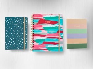 Imagem com fundo claro com planners com capa de estampas