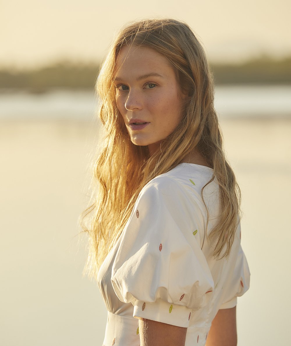 mulher loira usando uma blusa com mangas bufantes branca e estampada