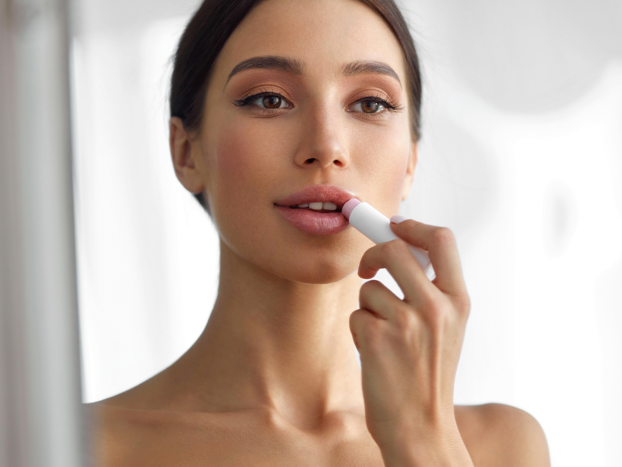 Imagem com uma mulher ilustrando como passar lip tint