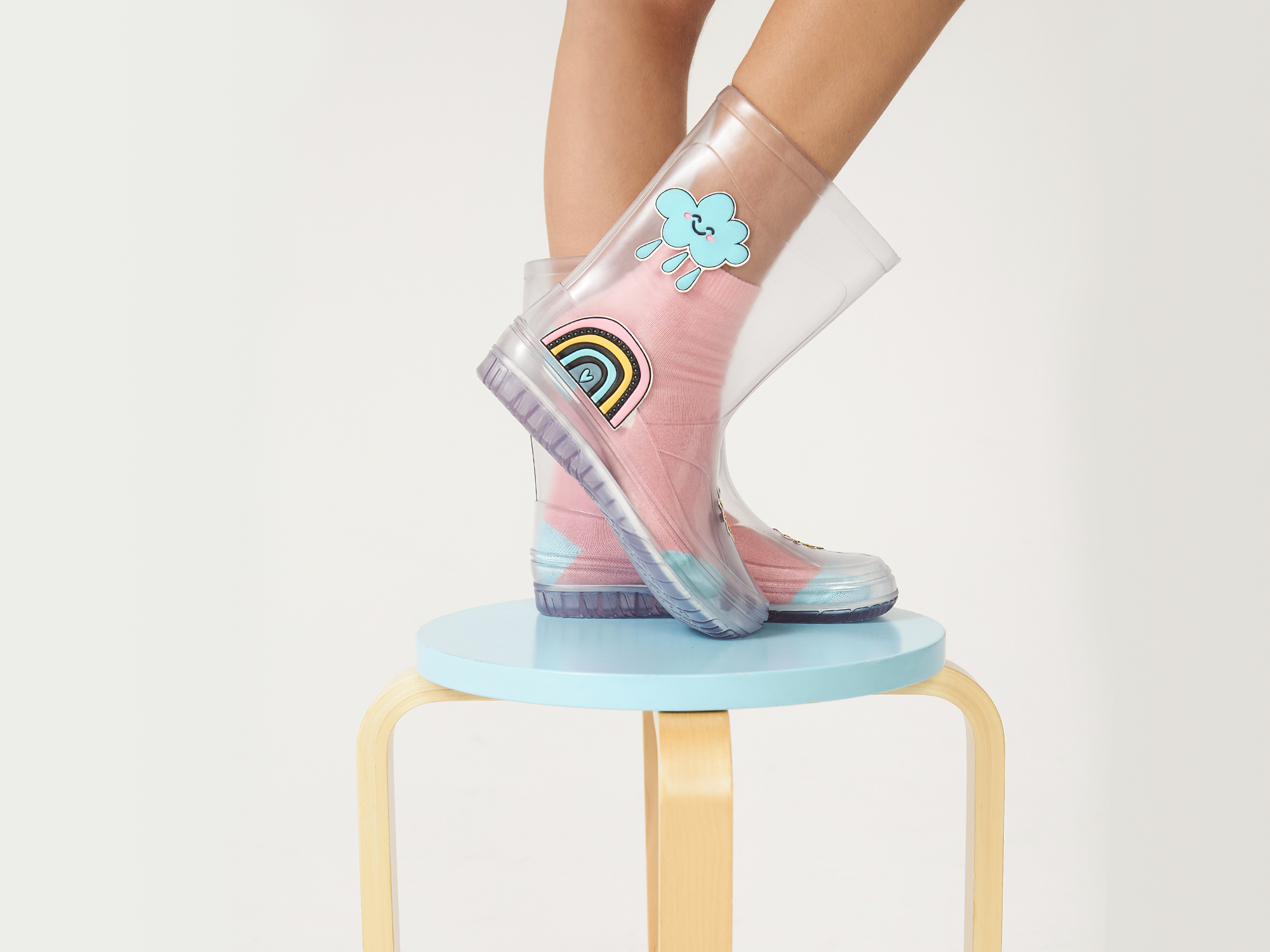 pé infantil com bota transparente colorida e meia rosa em roupa de inverno infantil