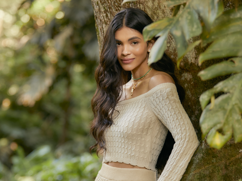 mulher encostada em árvore com roupas da campanha somos re moda responsável renner